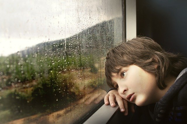 chlapec se dívá z okna
